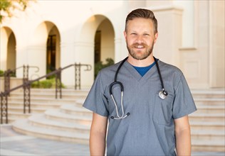 Caucasian male nurse in front of hospital building