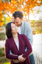 Outdoor fall portrait of chinese and caucasian young adult couple