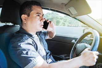 Concept of man calling on the phone while driving