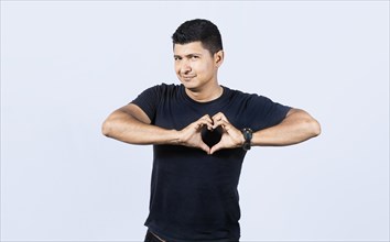 Man forming a heart with his fingers on isolated background