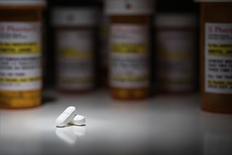 Hydrocodone pills and prescription bottles under spot light