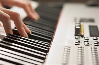 Woman's fingers on digital piano keys