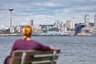 Woman sitting on bench looking at the seattle