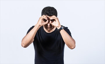 Curious man making binoculars gesture