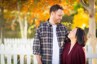 Outdoor fall portrait of chinese and caucasian young adult couple