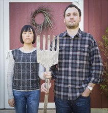 Fun mixed-race couple portrait simulating the american gothic painting by grant wood