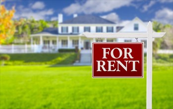 Red for rent real estate sign in front of beautiful house