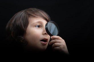 Boy with magnifying glass ready to explore
