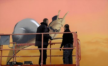 Graffity artist on a lifting platform during a commissioned work