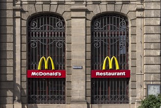 Mc Donald logos on the windows of a historic post office building