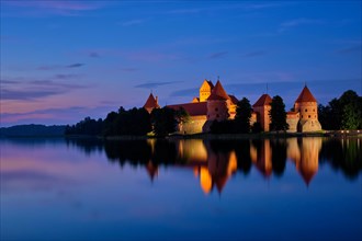 Night view of Trakai Island Castle in lake Galve illuminated in the evening