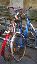 Alte Fahrraeder stehen abgesperrt im Fahrradstaender