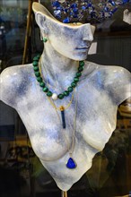 Marble bust with necklaces in shop window