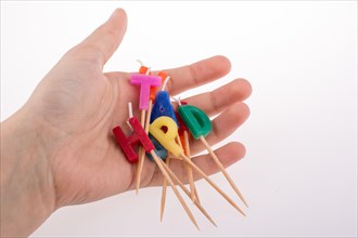 Hand holding letters made of candles on sticks