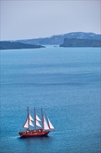 Tourist schooner vessel ship boat in Aegean sea near Santorini island with tourists going to sunset viewpoint