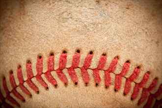 Macro abstract detail of worn leather baseball with vignette