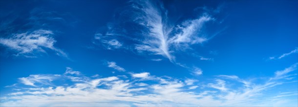 Blue clear sky with white cirrus spindrift clouds background panorama