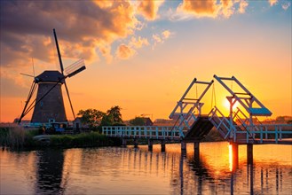 Netherlands rural landscape with windmills and bridge at famous tourist site Kinderdijk in Holland on sunset with dramatic sky