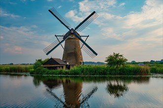 Netherlands rural lanscape with windmills at famous tourist site Kinderdijk in Holland on sunset with dramatic sky
