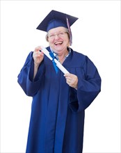 Happy senior adult woman graduate in cap and gown holding diploma isolated on a white background