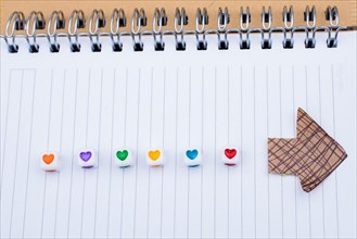 Love cubes and paper arrow on a notebook on canvas