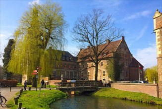 View of the excursion destination Westphalian moated castle Raesfeld in beginning spring with budding trees