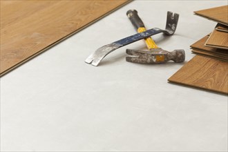 Worn hammer and pry bar with laminate flooring abstract with copy room