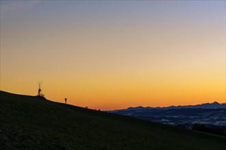 Handyfotograf bei Sonnenaufgang auf Bergruecken