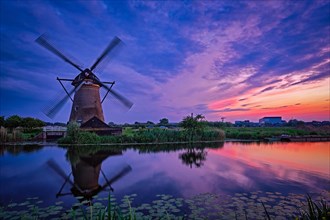Netherlands rural landscape with windmills at famous tourist site Kinderdijk in Holland in dusk with dramatic sky