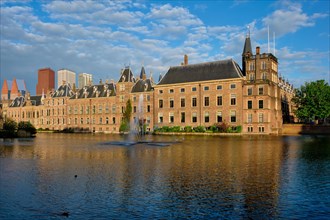 View of the Binnenhof House of Parliament and the Hofvijver lake with downtown skyscrapers in background