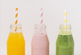 Assorted delicious fruit smoothies bottles with straws