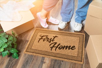 Man and woman unpacking near first home welcome mat