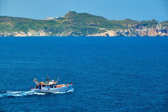 Greek fishing boat in blue waters of Aegean sea near Milos island