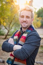 Handsome young adult male wearing scarf portrait outdoors