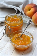 Peach jam in glass bowl and peaches