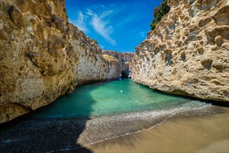 Papafragas hidden beach with crystal clear turquoise water and tunnel rock formations in Milos island