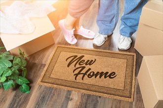 Man and woman unpacking near new home welcome mat