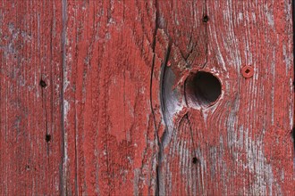 Wooden board with knothole painted in red