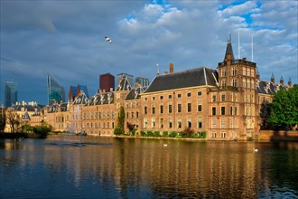 View of the Binnenhof House of Parliament and the Hofvijver lake with downtown skyscrapers in background. The Hague