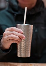 Man holding metal cup with milk tea
