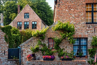 Old housesof Begijnhof Beguinage with flowers in Bruges town