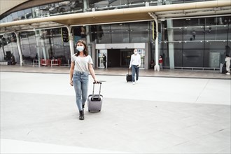 A young woman leaving the airport with her luggage ready to discover a new destination