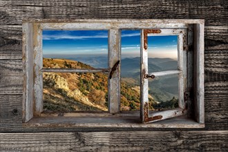 View through a rustic wooden window from the Belchen into the small Wiesental