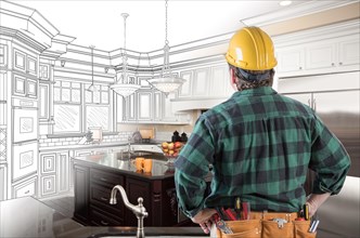 Male contractor with hard hat and tool belt looking at custom kitchen drawing photo combination on white