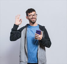 Pleasant person holding cellphone and winking