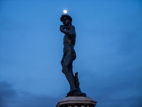 Full moon over the statue of David in Piazzale Michelangelo