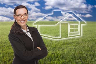 Smiling woman in grass field with ghosted house figure behind