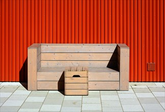 Holzbank mit Tisch vor organer Wand