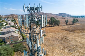 Close-up aerial of cellular wireless mobile data tower with neighborhood surrounding