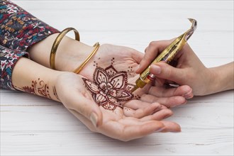 Artist making mehndi womans hands